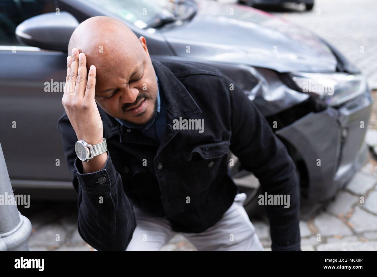 Accident de voiture et blessures. Automobile endommagée et homme africain Banque D'Images