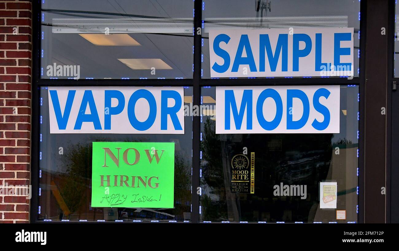 Emporia, Kansas, États-Unis. 6 mai 2021. Des affiches d'embauche sont maintenant affichées à la fenêtre de l'atelier local de fumée Vapor à Emporia, Kansas, alors que les entreprises cherchent à embaucher des employés et à augmenter la production normale après la pandémie de COVID-19, le 6 mai 2021. Crédit : Mark Reinstein/Media Punch/Alamy Live News Banque D'Images