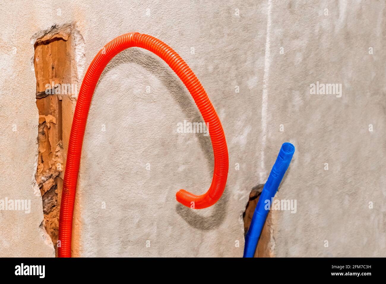 Matériau d'isolation de tuyau en PVC plastique sur construction béton réparation de mur domestique. Banque D'Images