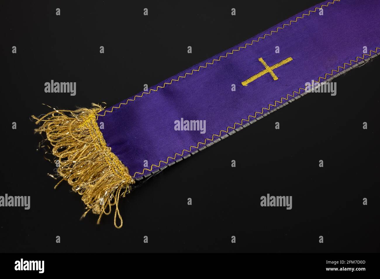 Taupe de prêtre violet avec une croix sur un noir arrière-plan Banque D'Images