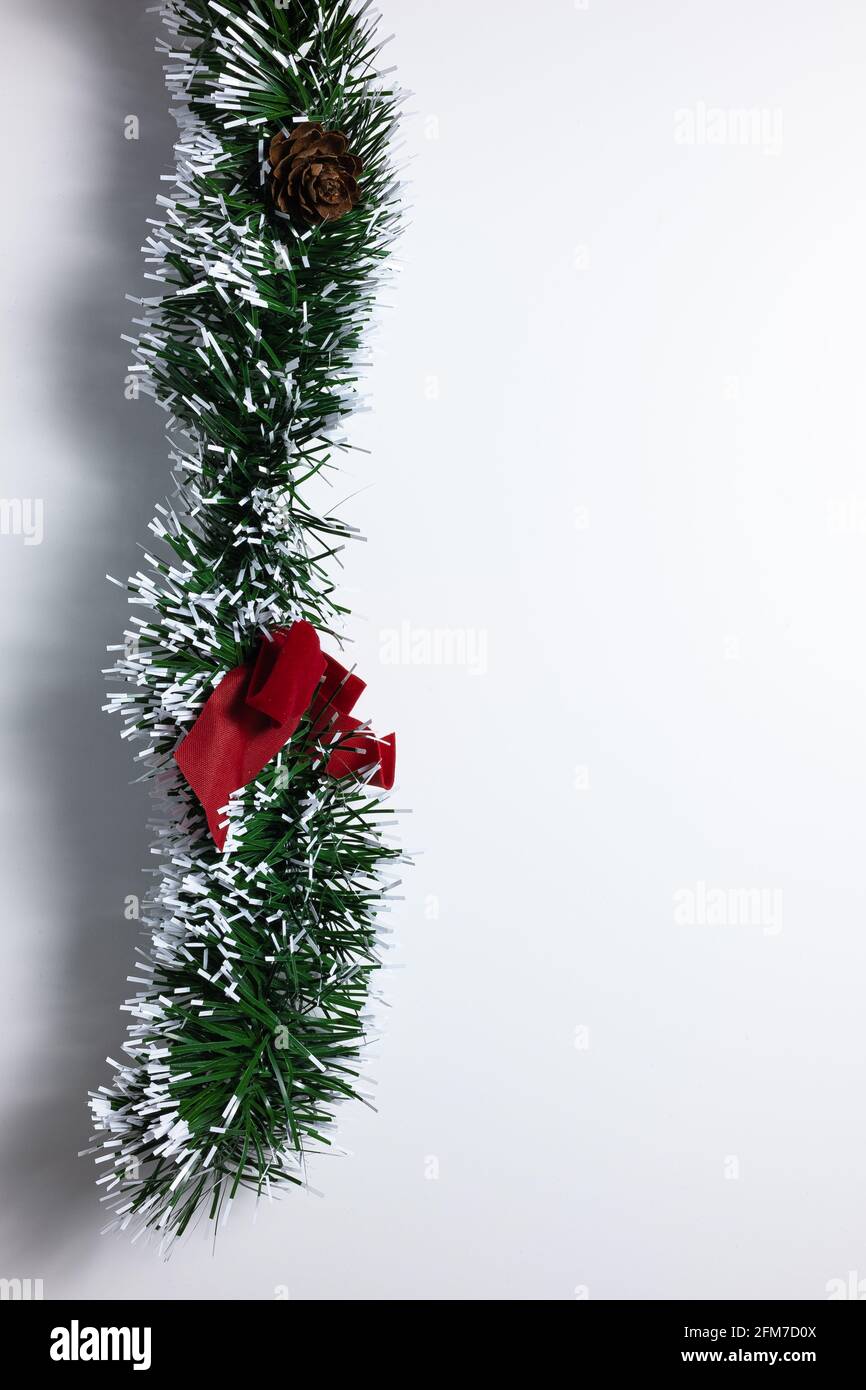 Couronne de Noël décorative verte avec décorations ajoutées et imitation neige sur fond blanc Banque D'Images