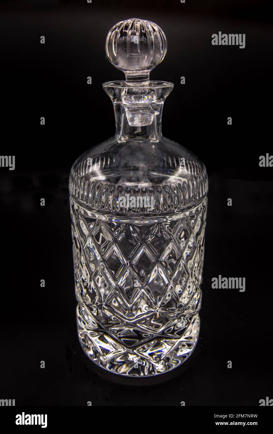 Carafe en cristal vide avec gravure, fermée avec un bouchon en verre sur  fond noir. Mise au point sélective Photo Stock - Alamy