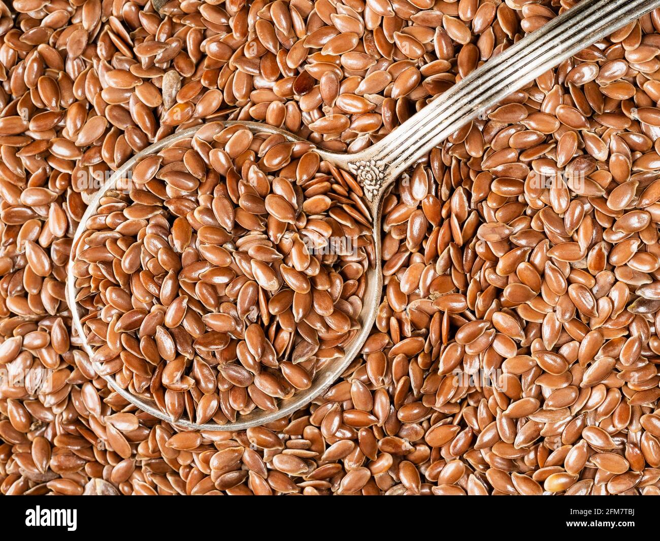 vue de dessus d'une cuillère à soupe d'argent en graines de lin brun en gros plan Banque D'Images