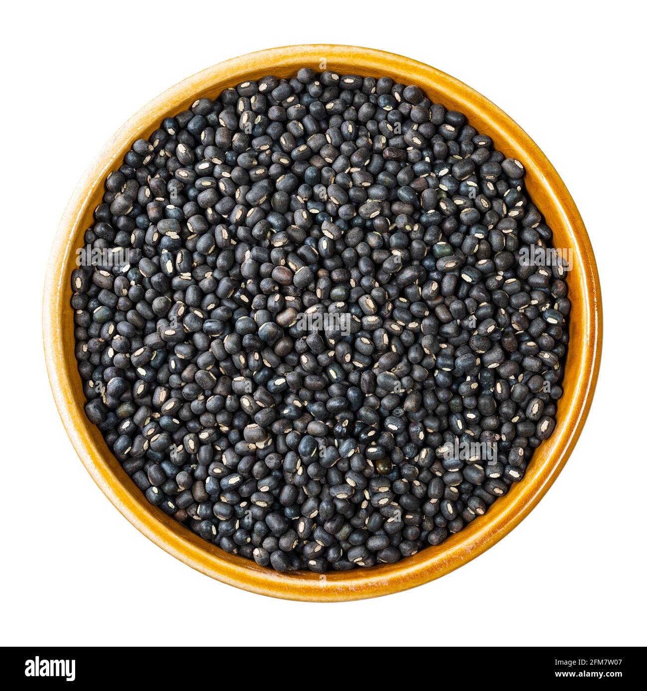 vue de dessus des grains d'urad noirs entiers crus en rond découpe du bol sur fond blanc Banque D'Images