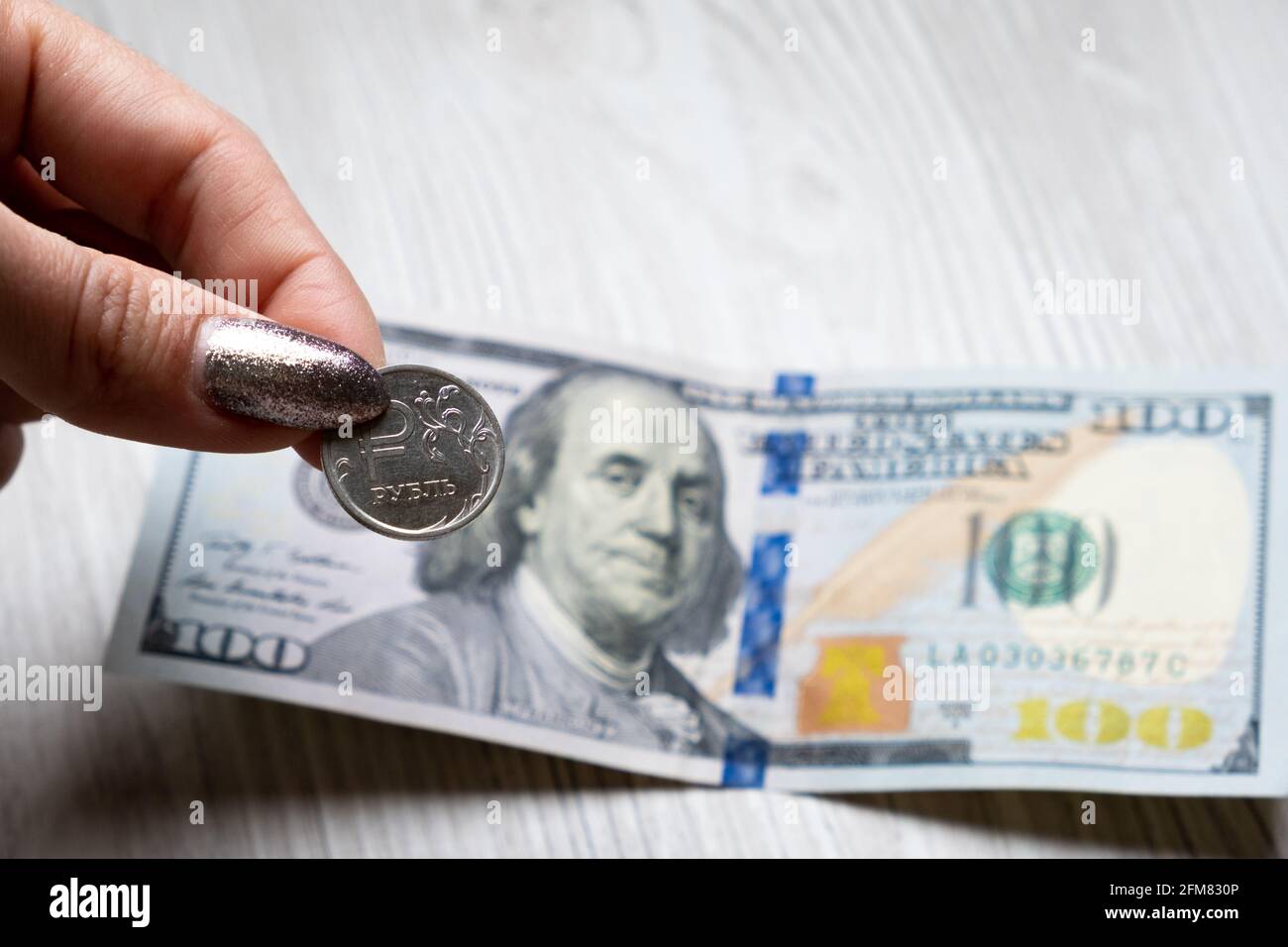 Une main féminine tient une pièce russe à un rouble sur une facture de ...