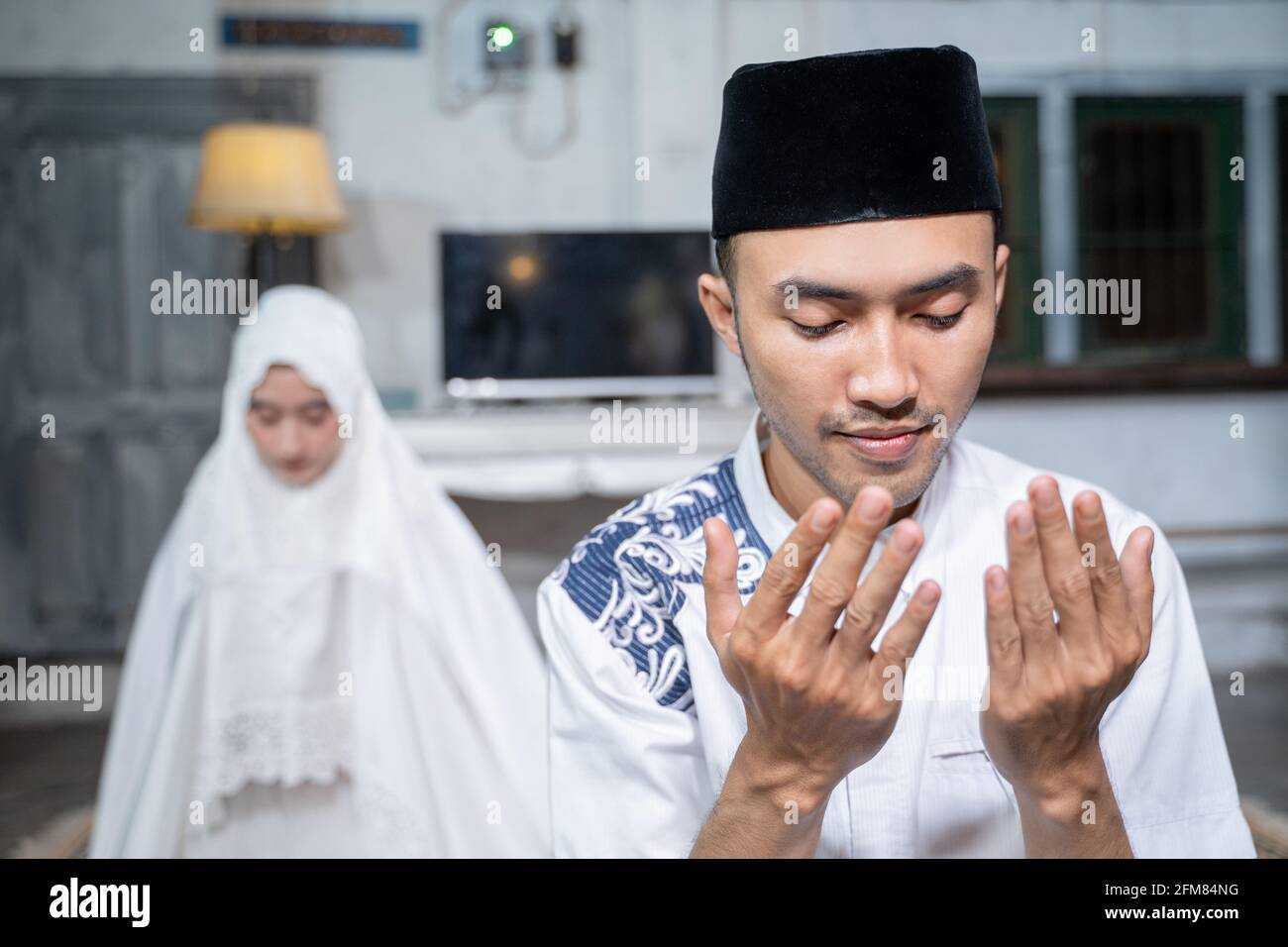 mari et femme musulmans priant la jamaah ensemble à la maison Banque D'Images