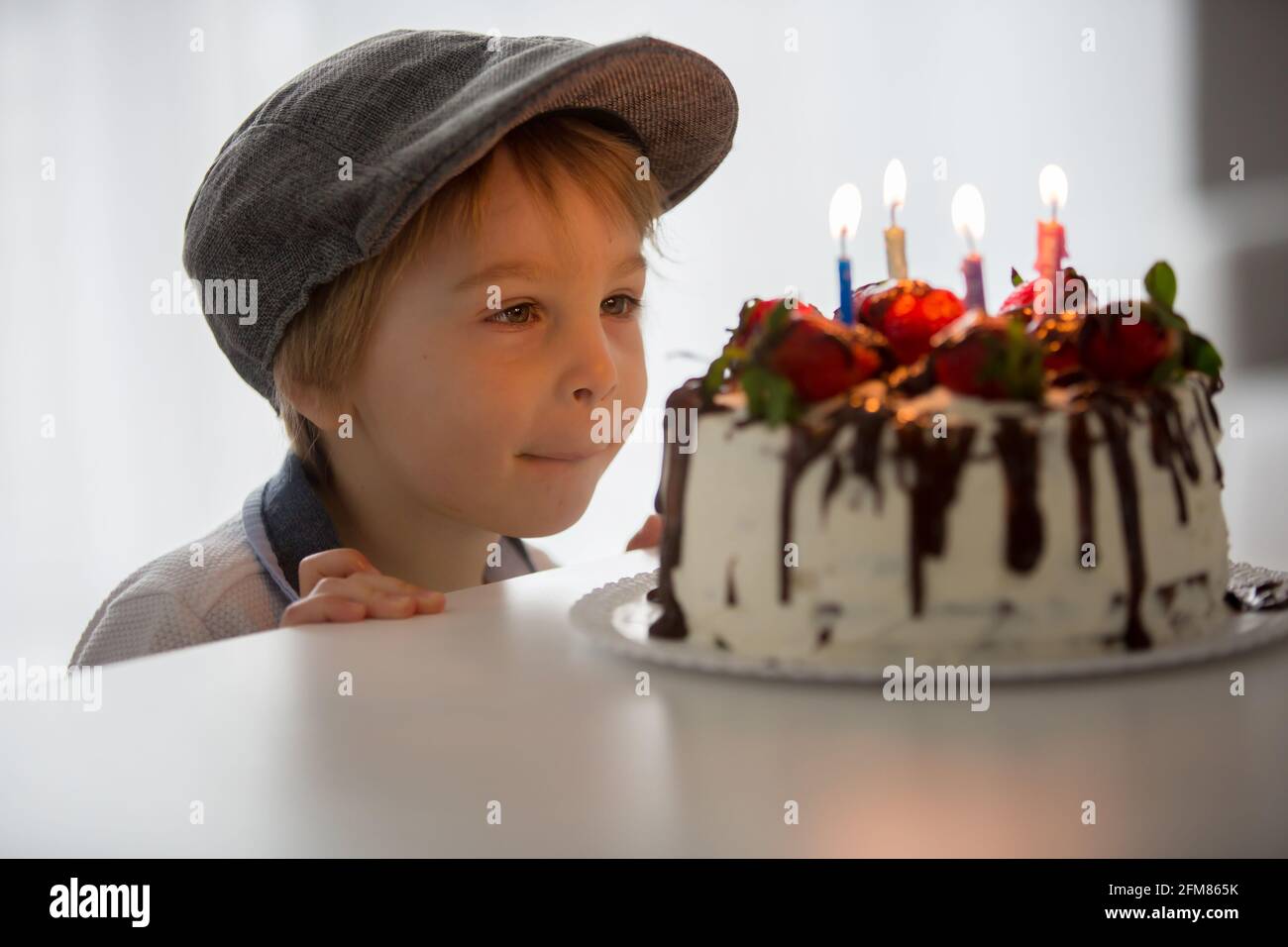 Enfant Blond De Quatre Ans Petit Garcon D Age Prescolaire Celebrant Son Anniversaire A La Maison Avec Un Gateau Fait Maison Avec Des Fraises Et Du Chocolat Photo Stock Alamy