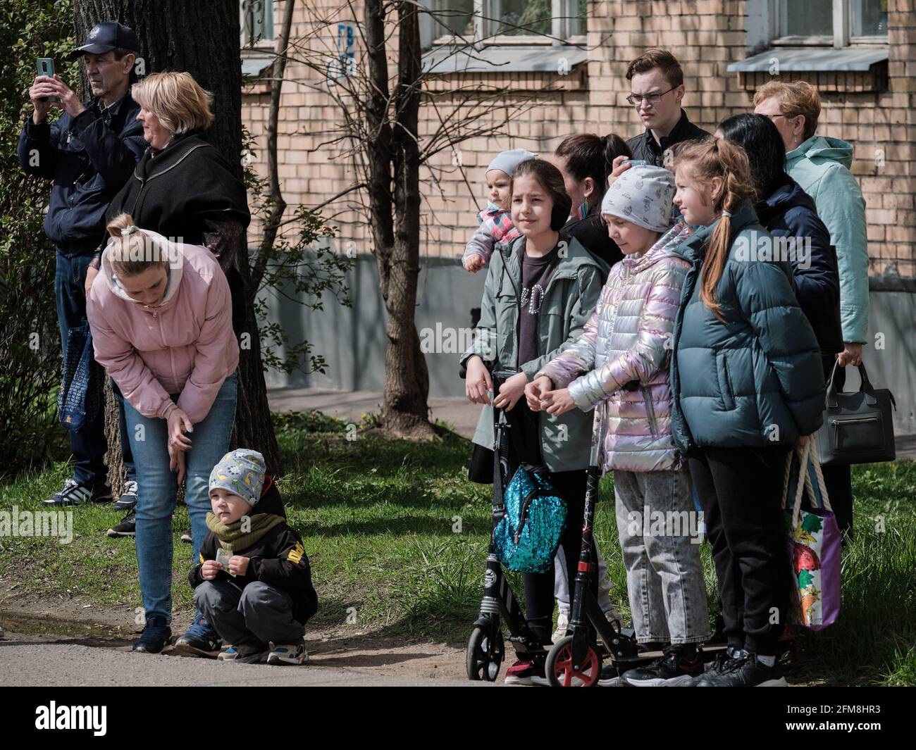 Passants avec enfants vus en regardant le spectacle. Les soldats de la Garde nationale à Moscou, à la veille du 9 mai, ont participé à l'action russe "Parade à la Maison des vétérans". Ils ont félicité les anciens combattants de la Grande Guerre patriotique vivant à Moscou. Les équipes de parade ont solennellement défilé sous les fenêtres des anciens combattants. De plus, des ensembles militaires ont donné des chansons bien connues des années de front aux anciens combattants, à leurs parents et à leurs voisins. Chaque ancien combattant a reçu un cadeau commémoratif. (Photo de Mihail Tokmakov/SOPA Images/Sipa USA) Banque D'Images