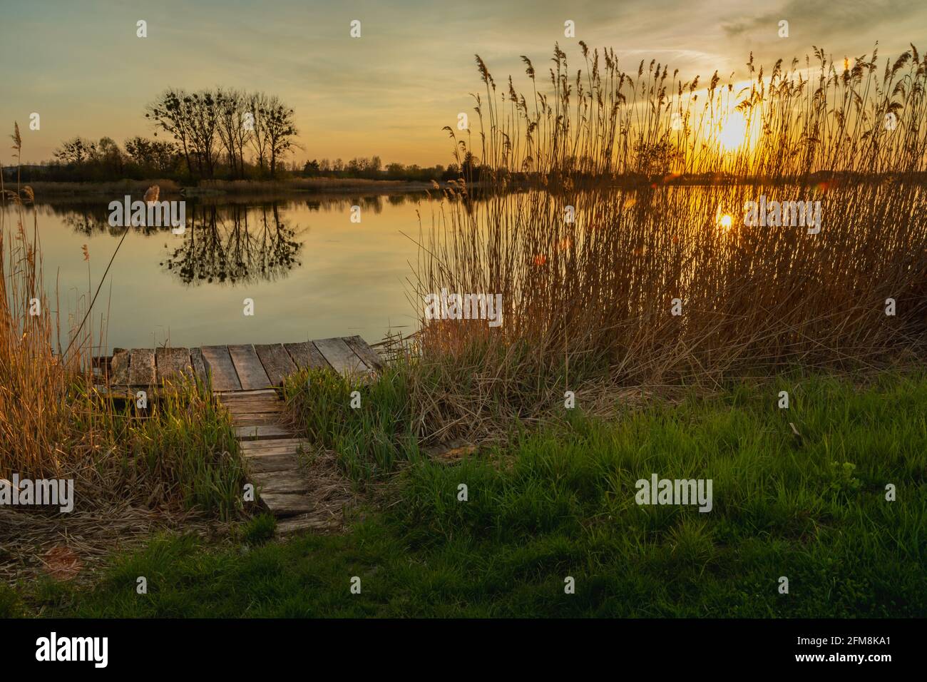 Plate-forme en bois au bord du lac et au coucher du soleil Banque D'Images