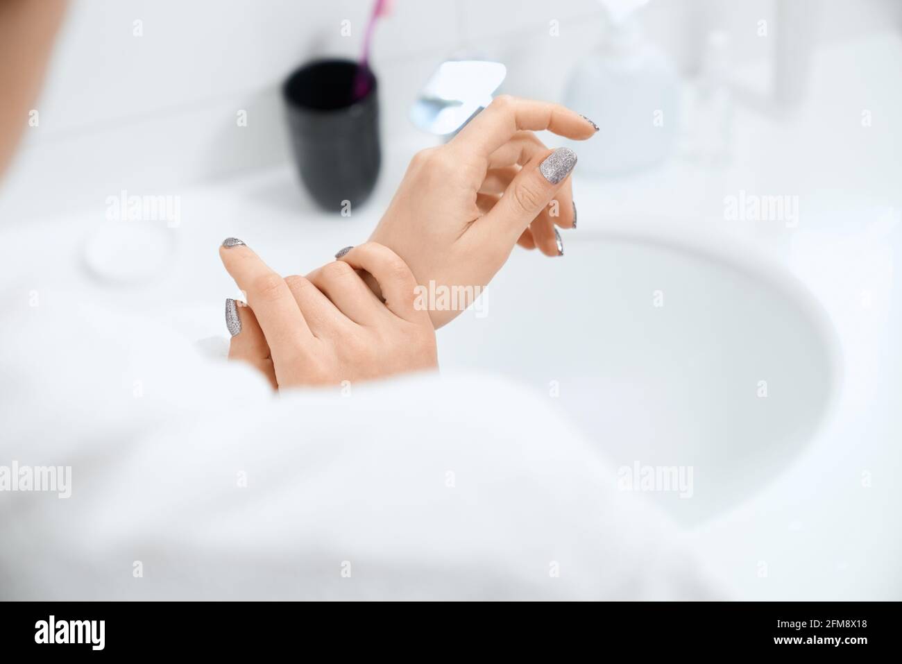 Gros plan de la jeune femme hydratez les mains crème spéciale après le  lavage avec du savon. Concept de soins pour les mains et le corps avec des  cosmétiques spéciaux à la