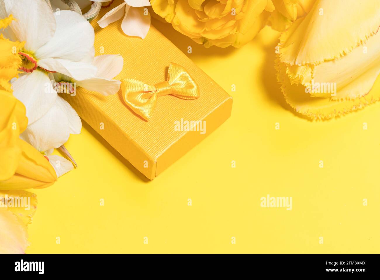 Aménagement jaune avec fleurs et boîte cadeau. Copier l'espace pour le  texte Photo Stock - Alamy