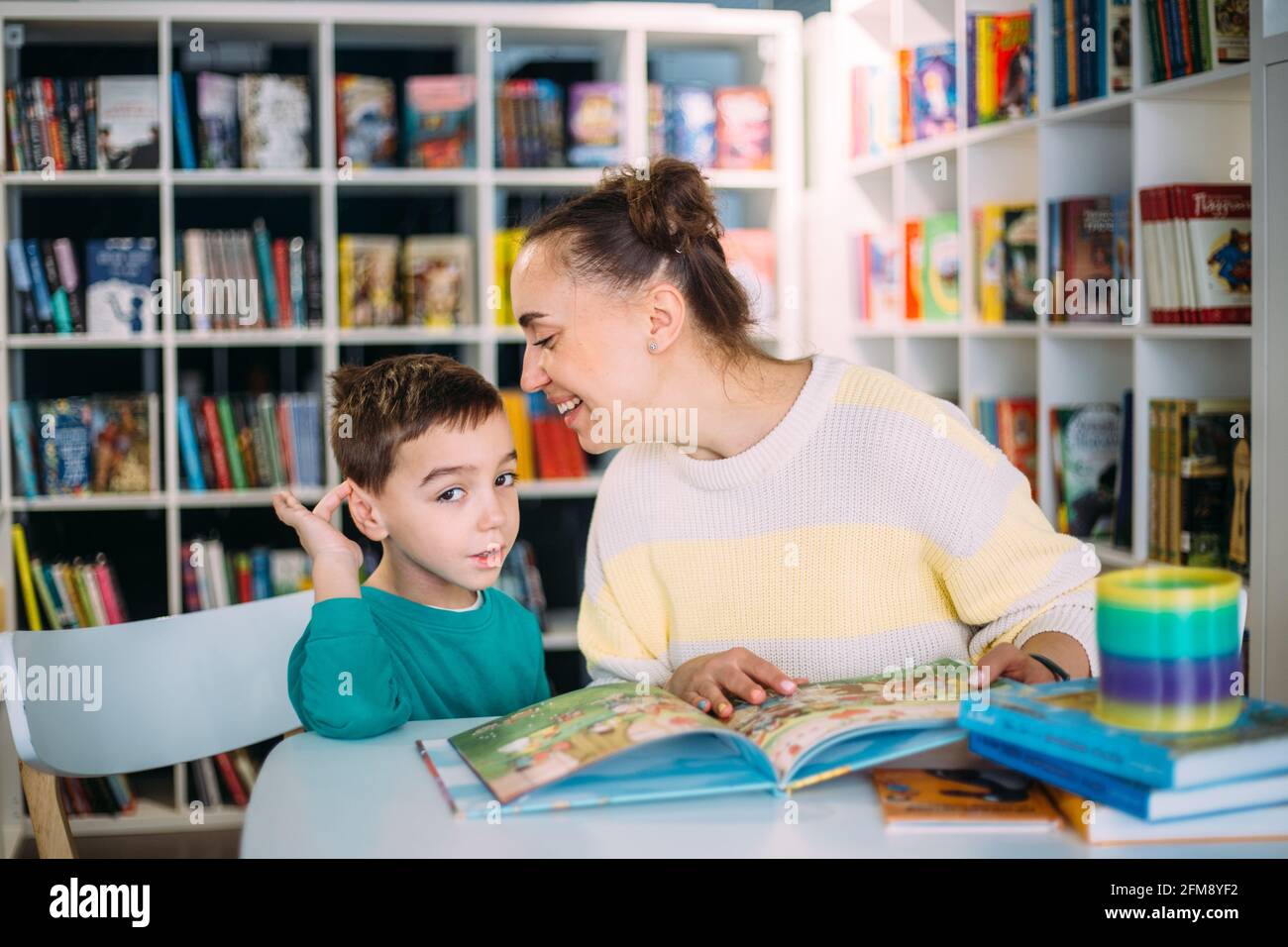 Maman et son petit enfant, le fils d'avant-garde, lisent ensemble les livres d'enfants Banque D'Images