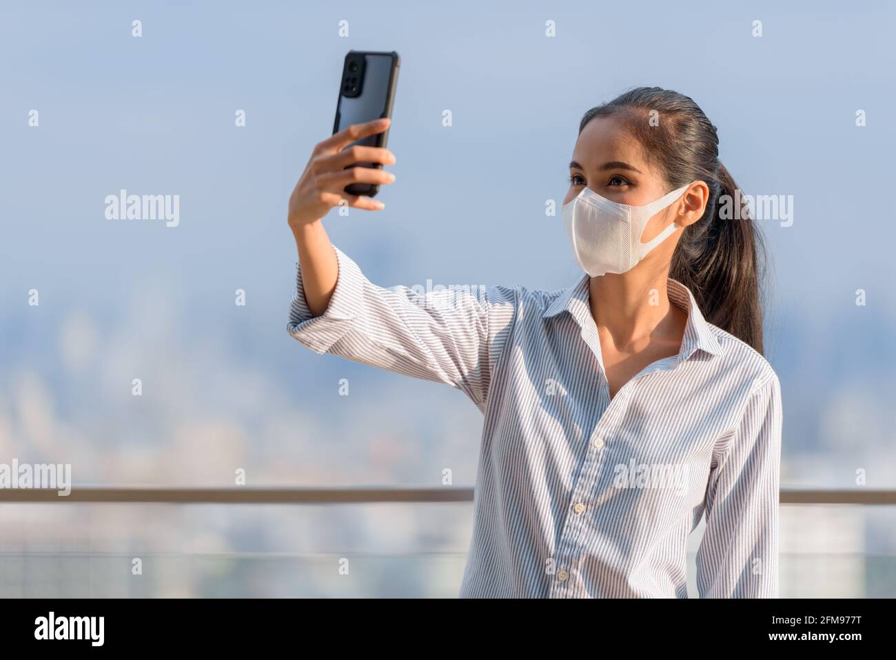 Femme asiatique portant un masque pour protéger contre le coronavirus Covid-19 tir horizontal Banque D'Images