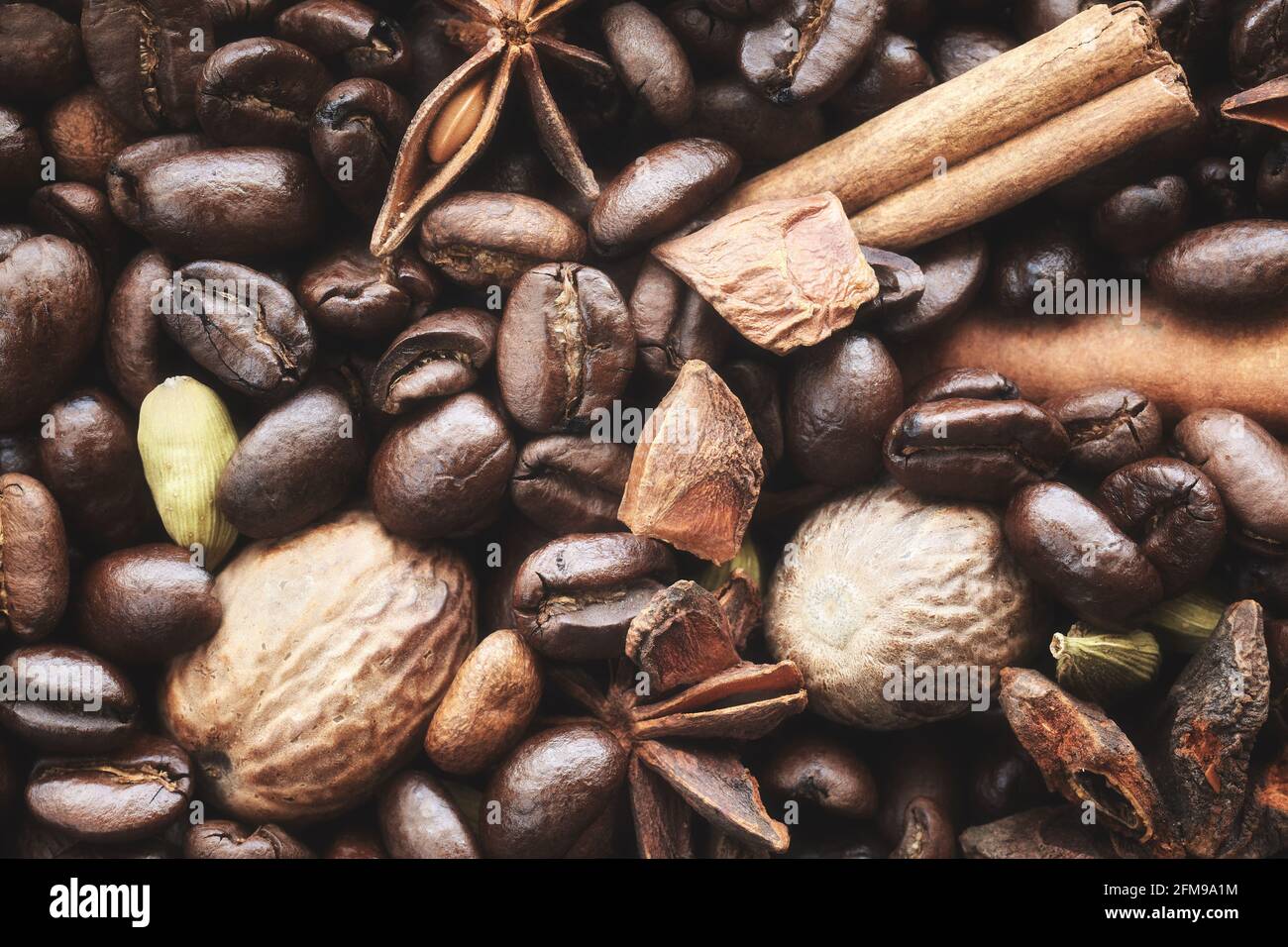 Gros plan de grains de café, anis, bâton de cannelle, dosettes de cardamome et muscade, mise au point sélective. Banque D'Images