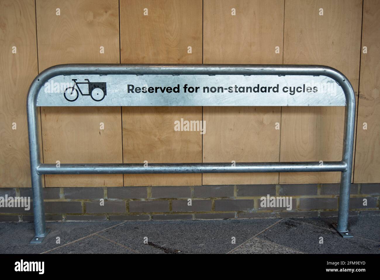 stand de vélo à la station de train de kingston cycle hub, surrey, angleterre, réservé aux cycles non standard et marqué avec du texte et un logo de vélo de cargaison Banque D'Images