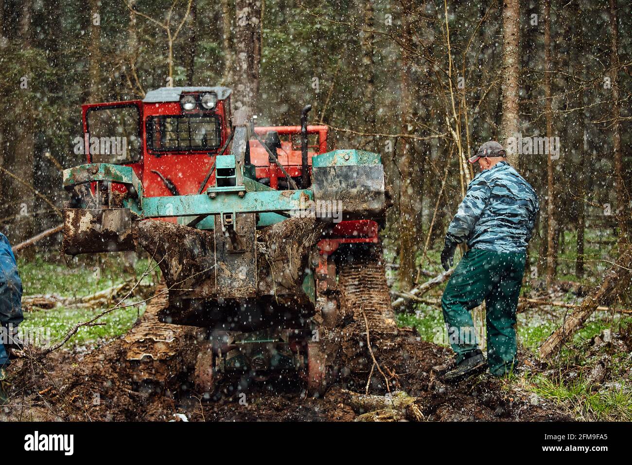 un tracteur à chenilles traverse une forêt de défrichement. un bulldozer industriel est coincé dans la boue. les camions glissent dans le sol Banque D'Images