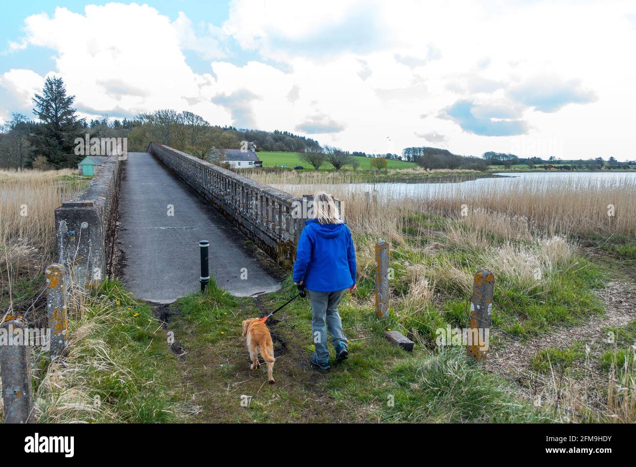 Un marcheur traverse le pont Logie Buchan War Memorial Bridge au-dessus de la rivière Ythan dans le petit hameau ou la paroisse de Logie Buchan, Aberdeenshire, Écosse, Royaume-Uni Banque D'Images