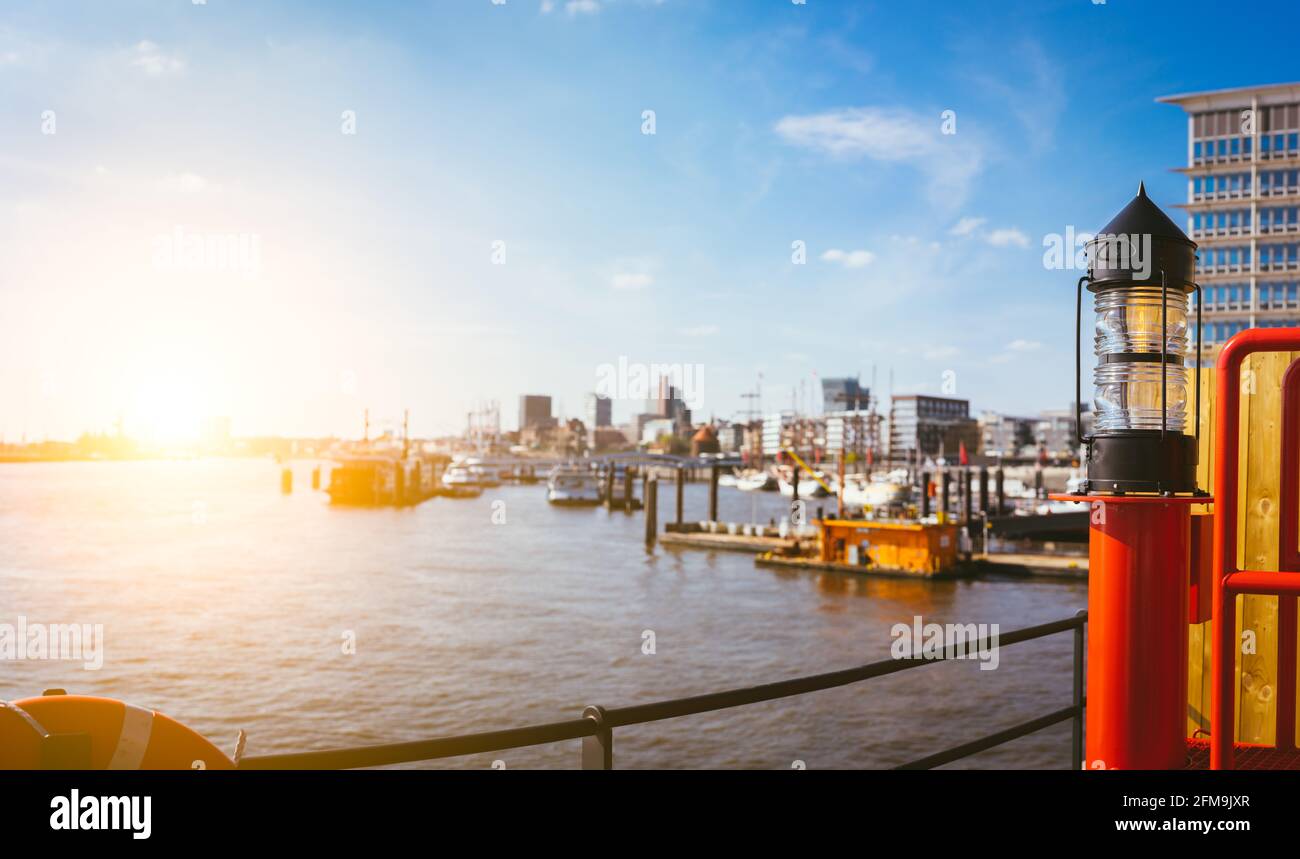 Panorama de hafencity - lanterne rouge à l'avant. Ciel bleu ciel lumineux avec lumière du soleil du soir. Piers de port avec navires et yacht à l'ancre. Hambourg, Allemagne. Banque D'Images