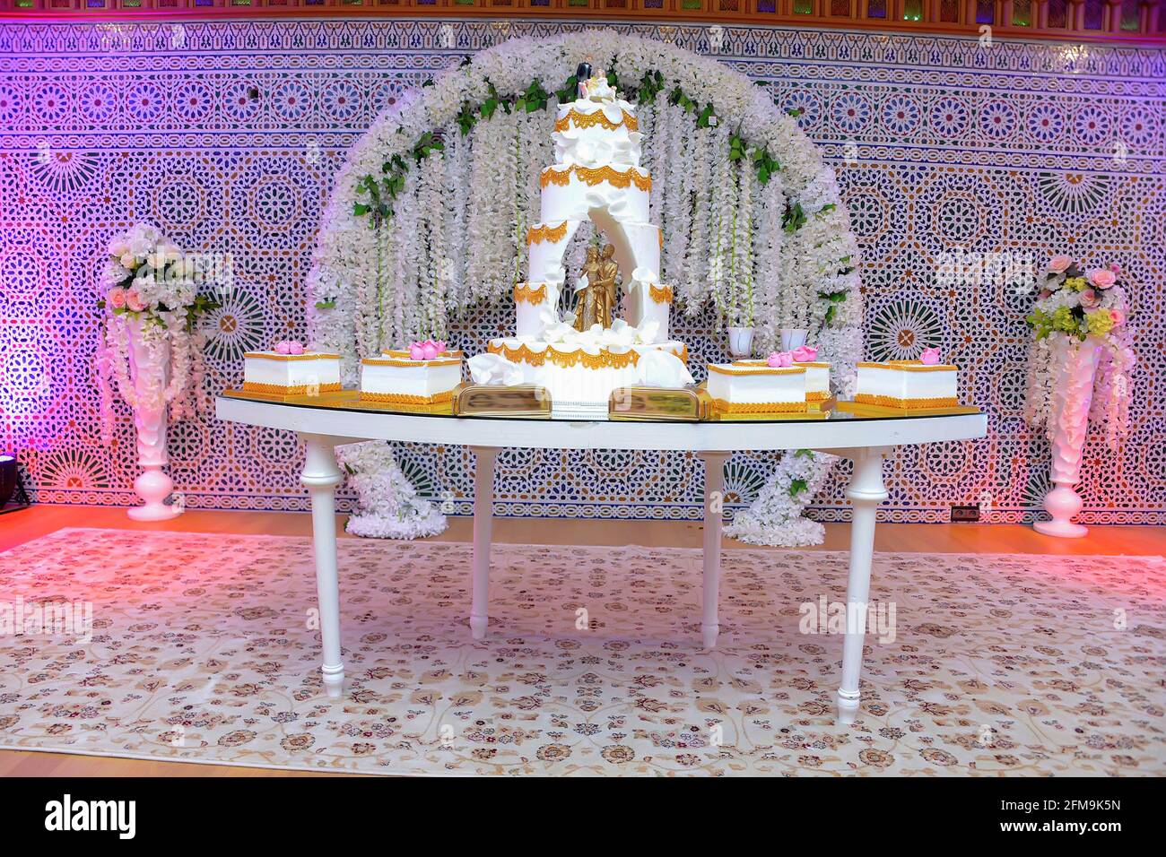 Gâteau de mariage luxueux avec statues de mariée. Un arrière-plan du zellige marocain Banque D'Images