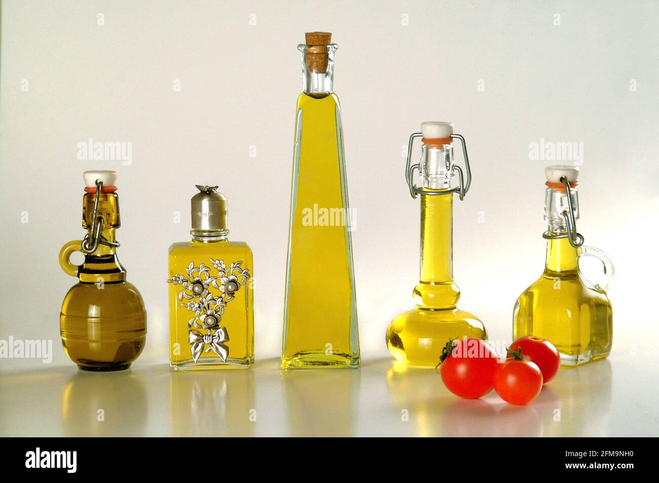 Cinq petites bouteilles d'huile d'olive extra vierge italienne arrière-plan clair Banque D'Images