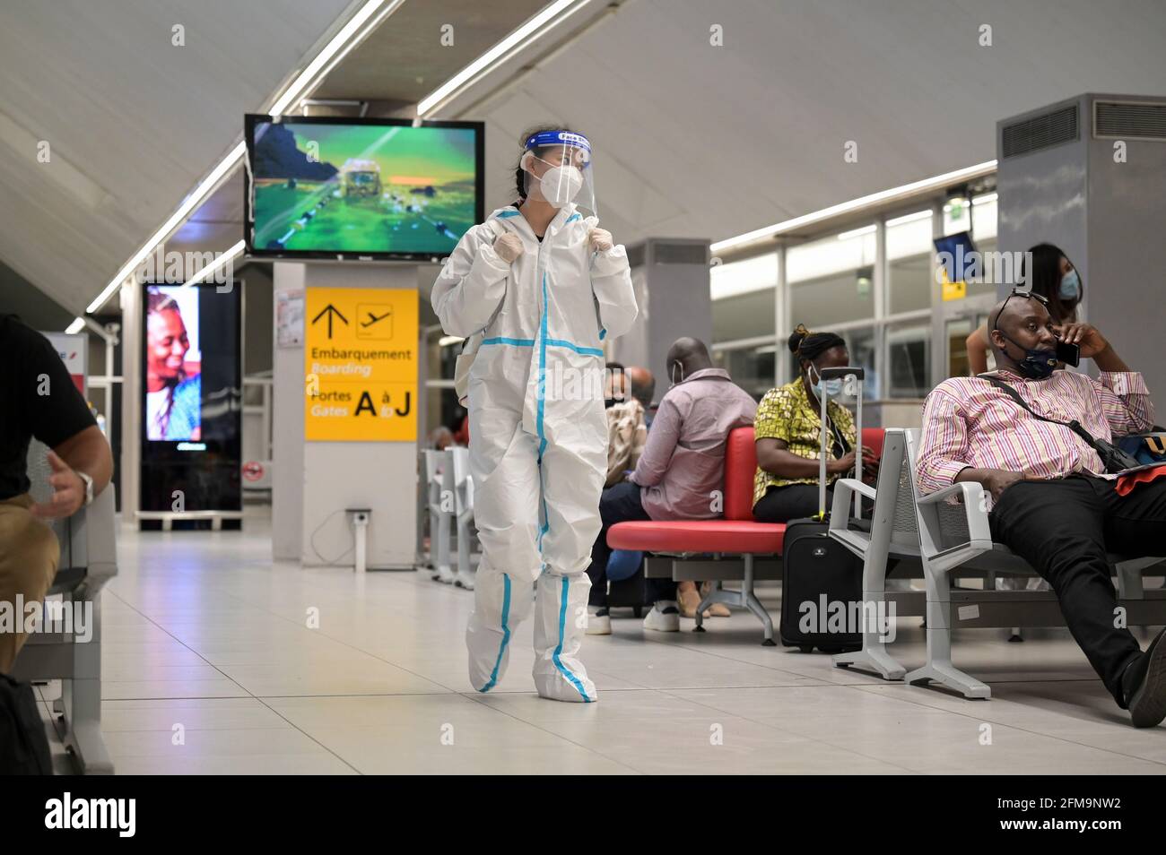 CÔTE D'IVOIRE, Abidjan, aéroport, chinois voyageur avec protection pendant la période de pandémie de Corona à la porte d'embarquement à Paris / ELFENBEINKÜSTE, Abidjan, Flughafen, Chinesische Reisende à Schutzkleidung während Corona Pandemie Banque D'Images