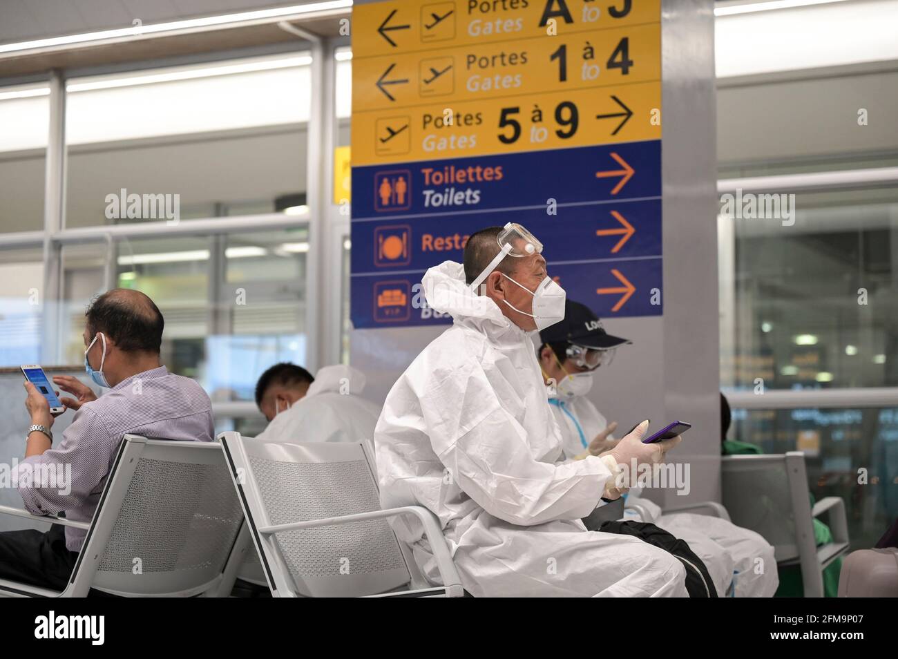 CÔTE D'IVOIRE, Abidjan, aéroport, chinois voyageur avec protection pendant la période de pandémie de Corona à la porte d'embarquement à Paris / ELFENBEINKÜSTE, Abidjan, Flughafen, Chinesische Reisende à Schutzkleidung während Corona Pandemie Banque D'Images