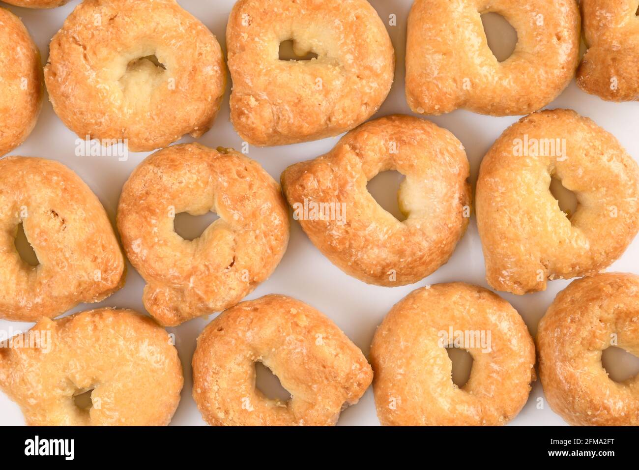 Taralli ou tarallini, en-cas traditionnel à l'italin à partir de pâte de blé. Arrière-plan de quelques pièces closeup isolé sur blanc. Banque D'Images