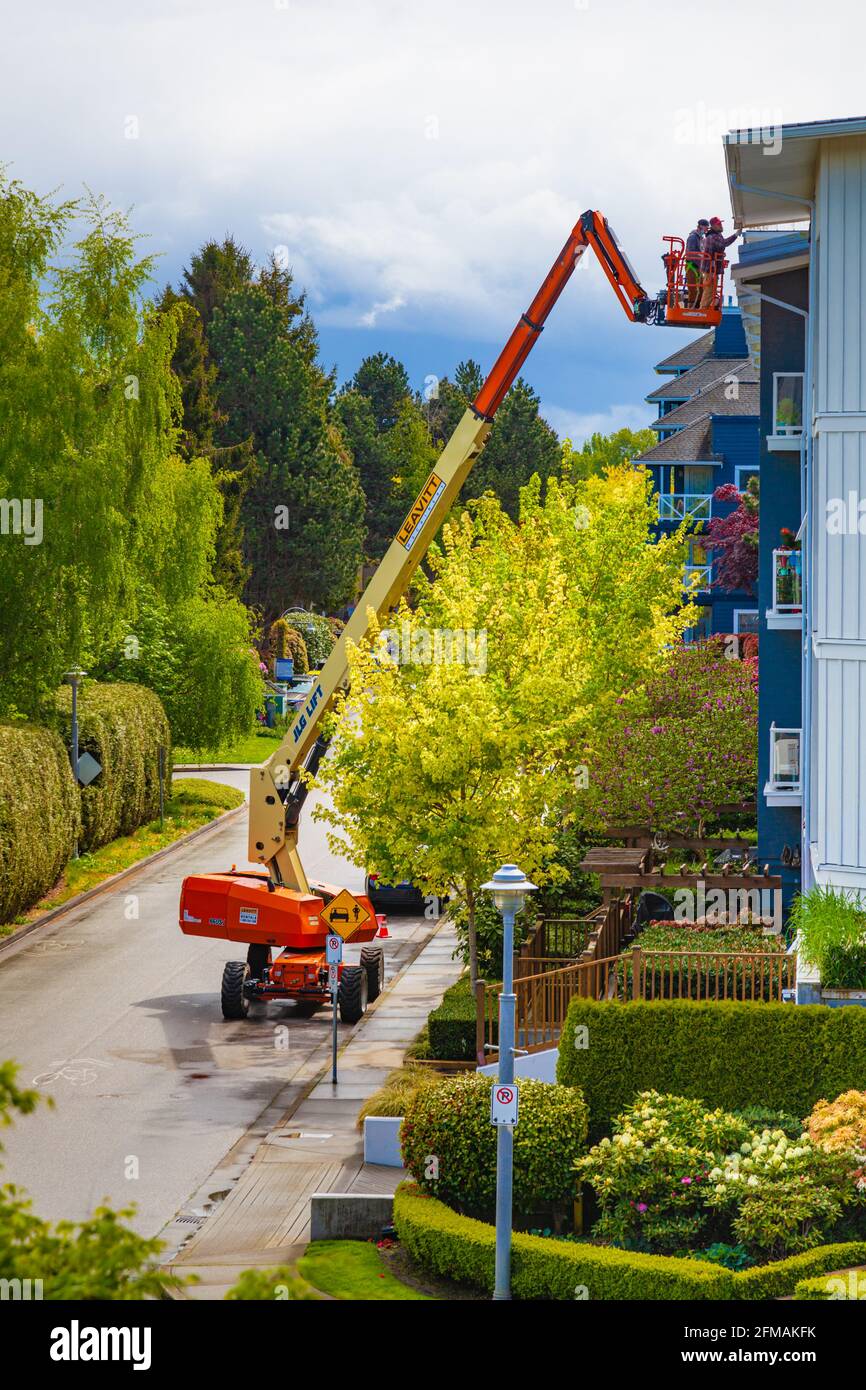 Deux travailleurs utilisant un ascenseur pour accéder au toit de Un immeuble d'appartements à Steveston Colombie-Britannique Canada Banque D'Images