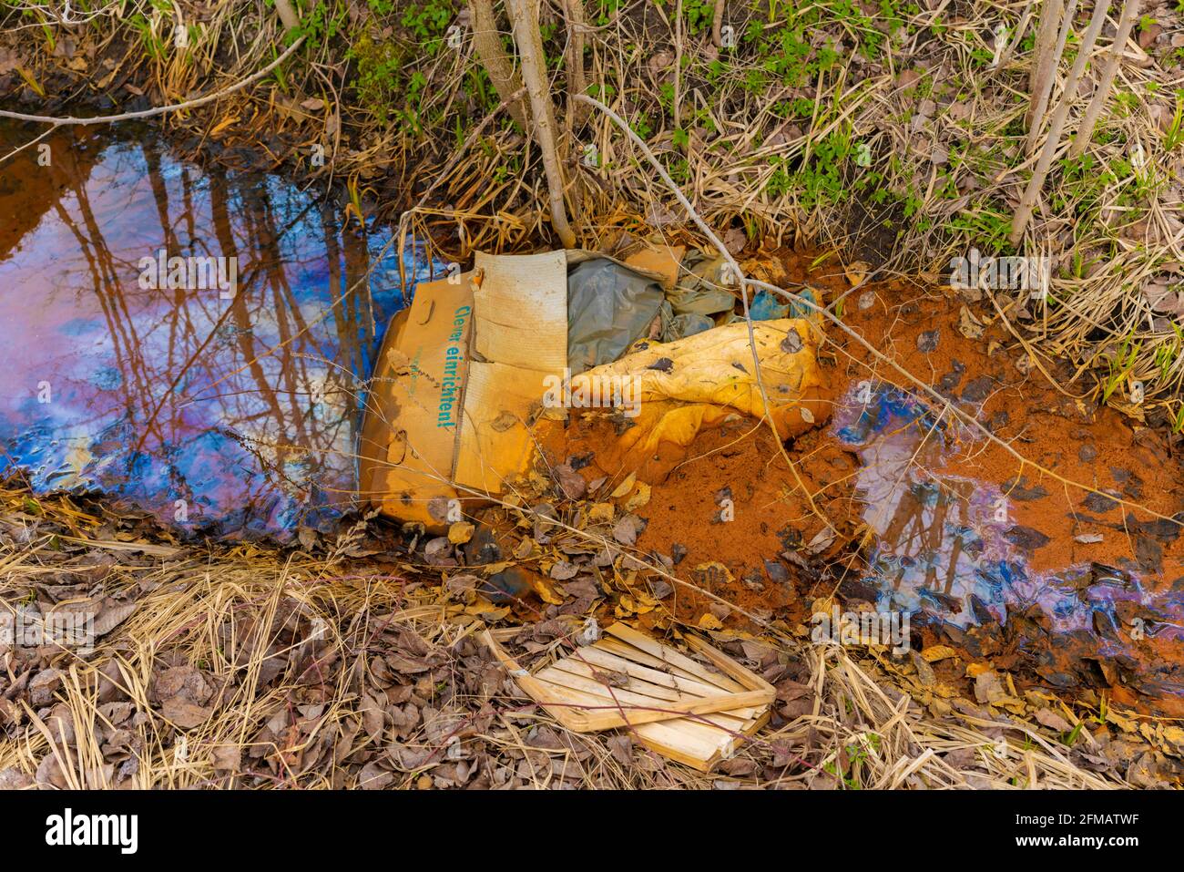 Déchets illégaux lycédés dans la forêt dans une petite rivière Banque D'Images