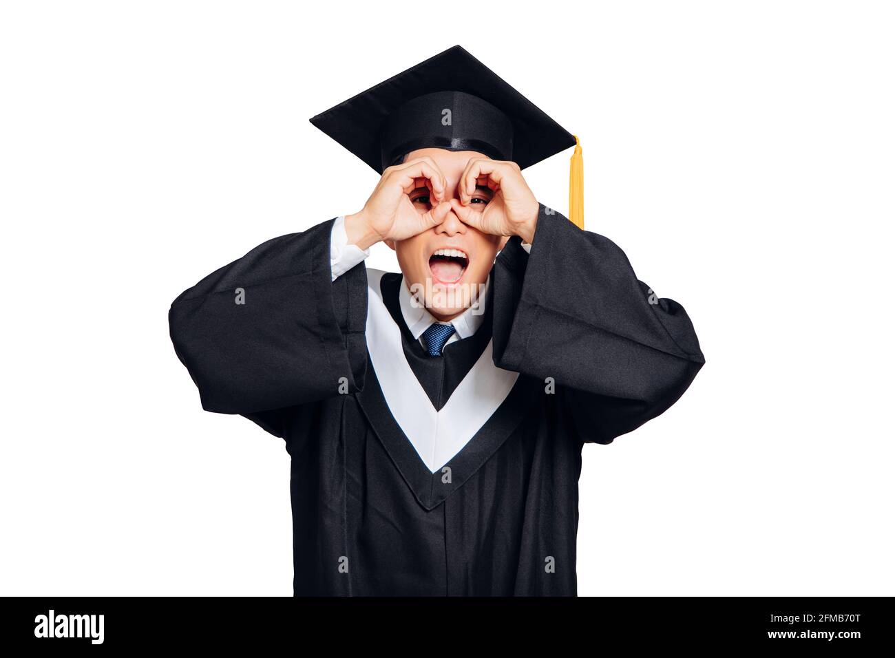 Œil de graduation mâle regardant à travers les mains avec le visage heureux Banque D'Images