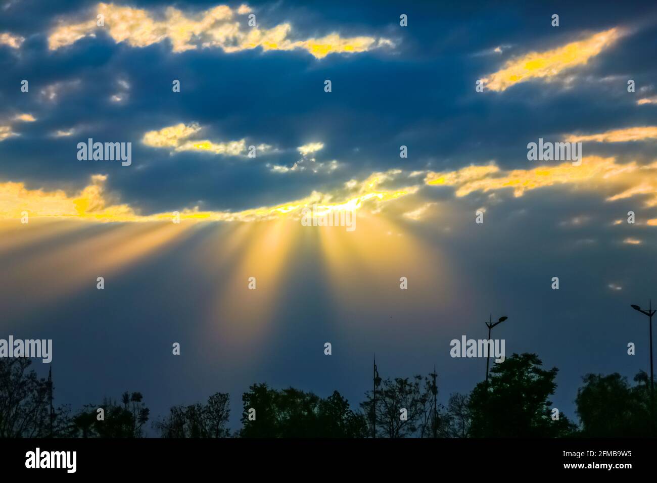 Des rayons de soleil jaunes naturels dans un ciel très nuageux Banque D'Images