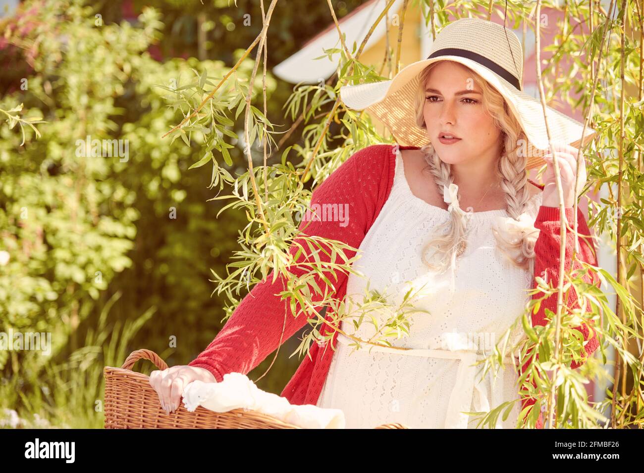 Jeune femme blonde avec chapeau et panier à linge Banque D'Images