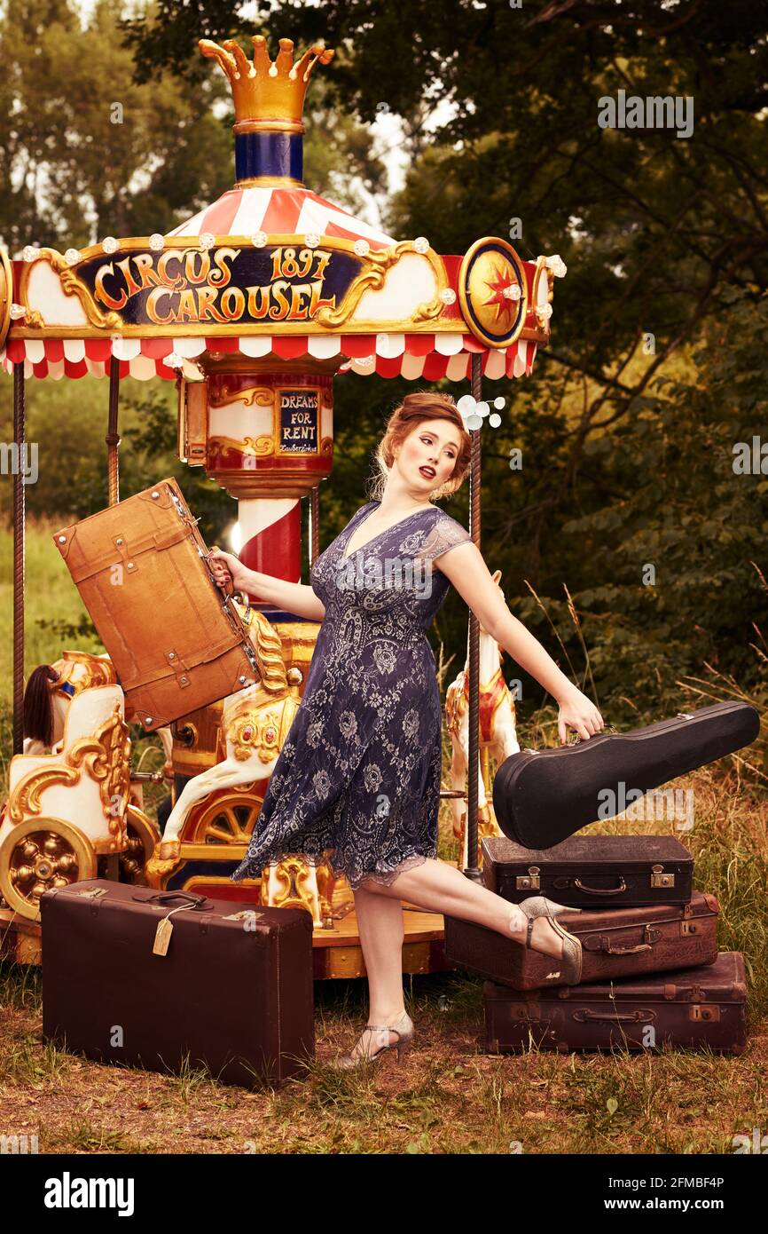 Jeune femme aux cheveux rouges et aux taches de rousseur sur une nostalgique carrousel Banque D'Images