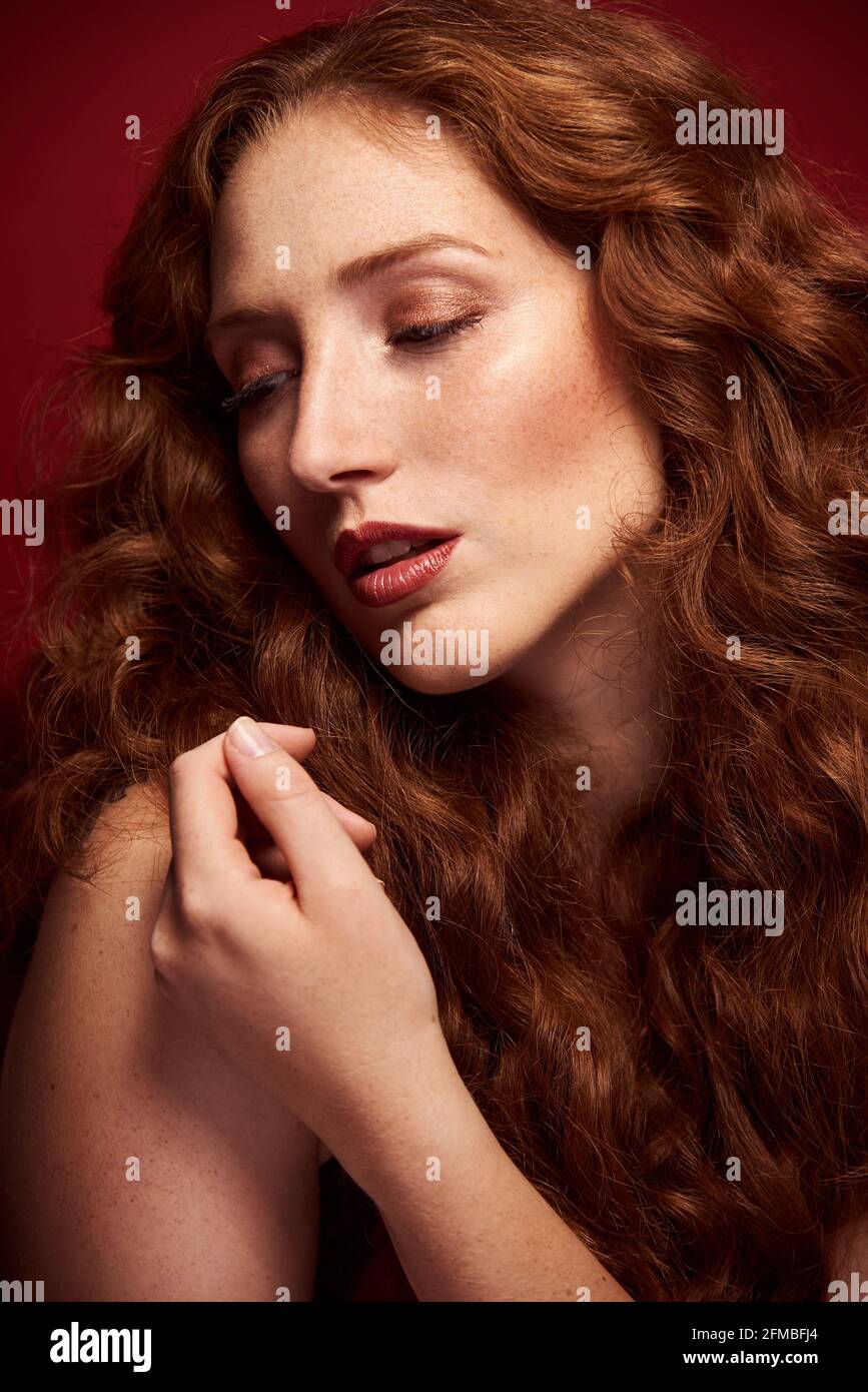 Jeune femme aux cheveux rouges luxuriants et aux taches de rousseur Banque D'Images