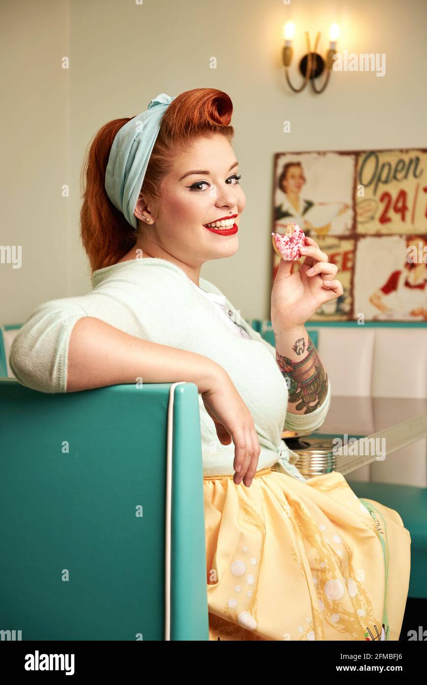 Jeune femme à cheveux rouges dans un bar à lait rétro Banque D'Images