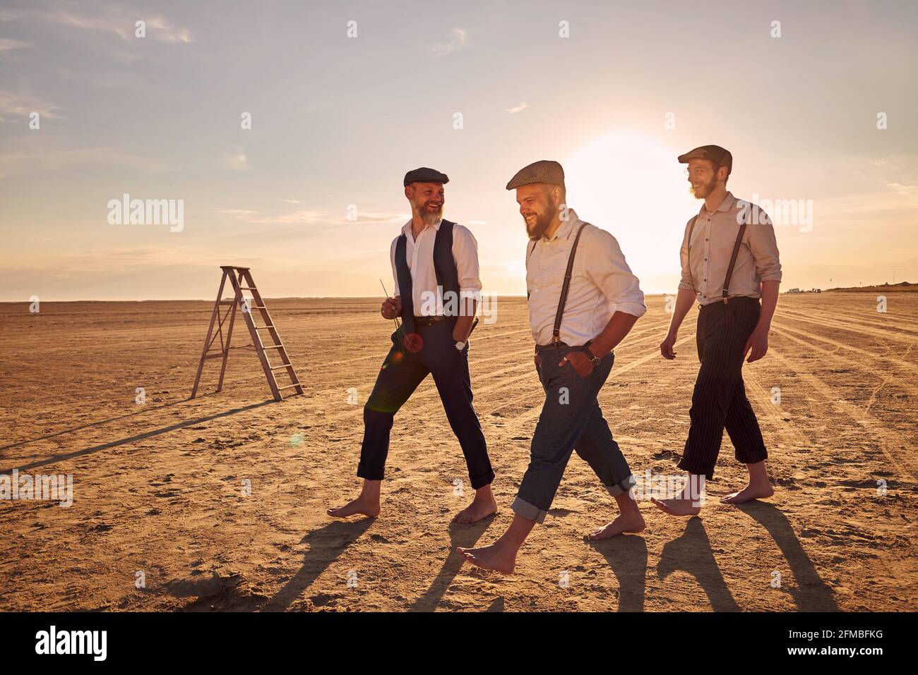 Trois hommes dans un look rétro dans la lumière du soir Sur la plage de Romo Banque D'Images