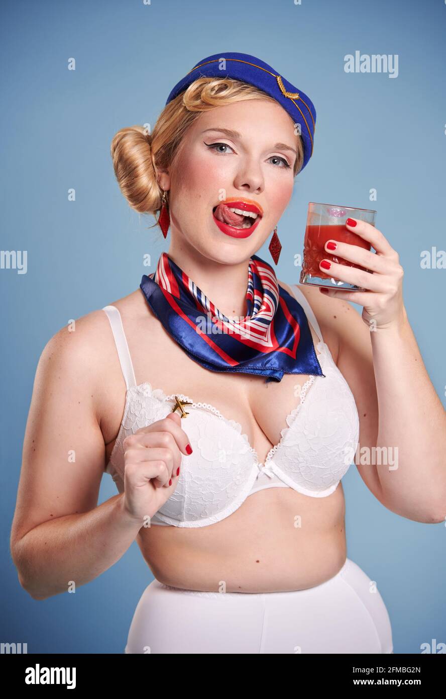 Jeune femme blonde en tant qu'hôtesse dans le regard de pin-up jus de tomate Banque D'Images