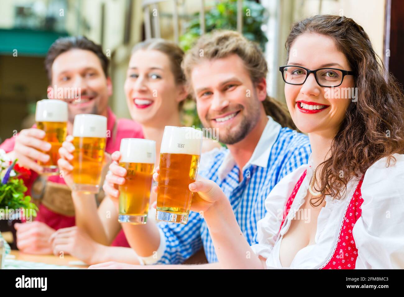 Amis de Tracht bavaroise traditionnelle dans un restaurant ou un pub avec de la bière en Bavière, Allemagne Banque D'Images