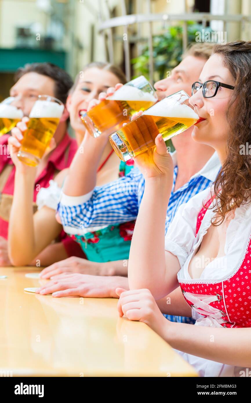 Amis de Tracht bavaroise traditionnelle dans un restaurant ou un pub avec de la bière en Bavière, Allemagne Banque D'Images