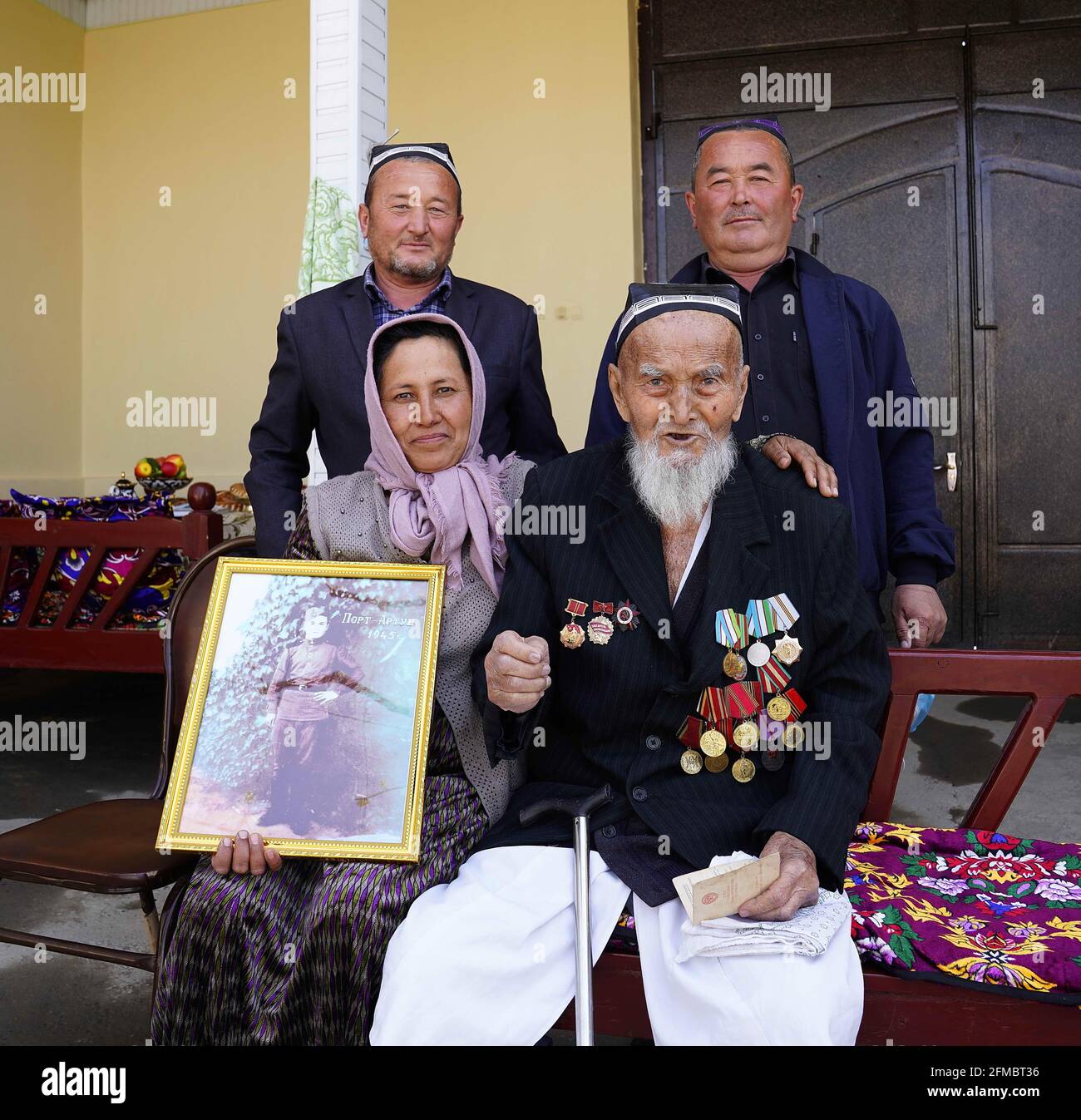 Tachkent, Ouzbékistan. 8 avril 2021. Khomidzhon Uzganov, vétéran de l'Armée rouge soviétique, pose pour des photos avec des membres de sa famille dans la région de Fergana, en Ouzbékistan, le 8 avril 2021. POUR ALLER AVEC 'Feature: Les anciens combattants de l'Armée rouge soviétique se rappellent les jeunes flamboyants dans les provinces du nord-est de la Chine crédit: CAI Guodong/Xinhua/Alamy Live News Banque D'Images