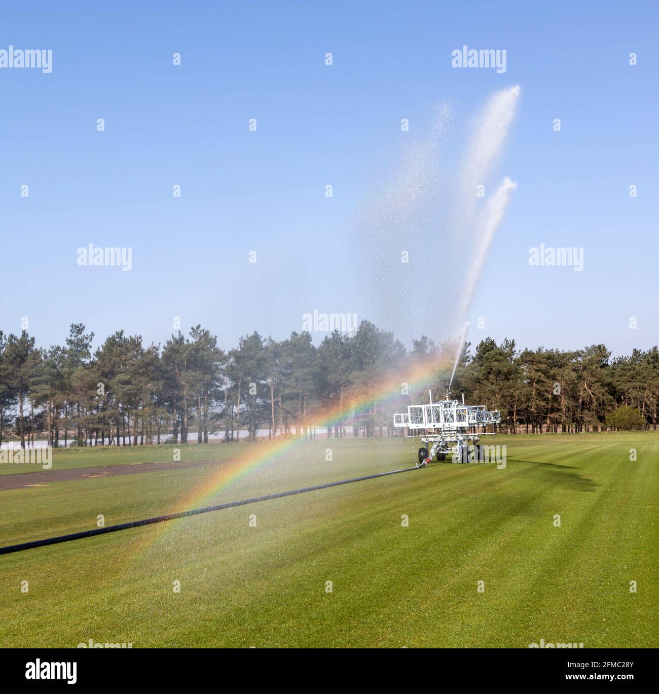Machine d'irrigation pour la pulvérisation d'eau sur gazon, Sutton Heath, Suffolk, Angleterre, Royaume-Uni Banque D'Images