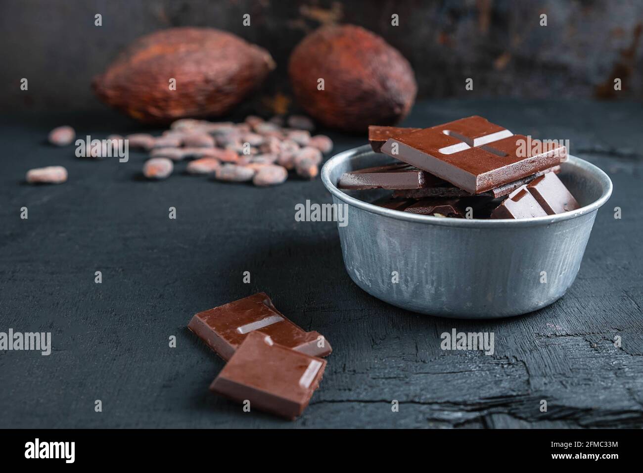 Morceaux de chocolat noir et fèves de cacao sur la table Banque D'Images