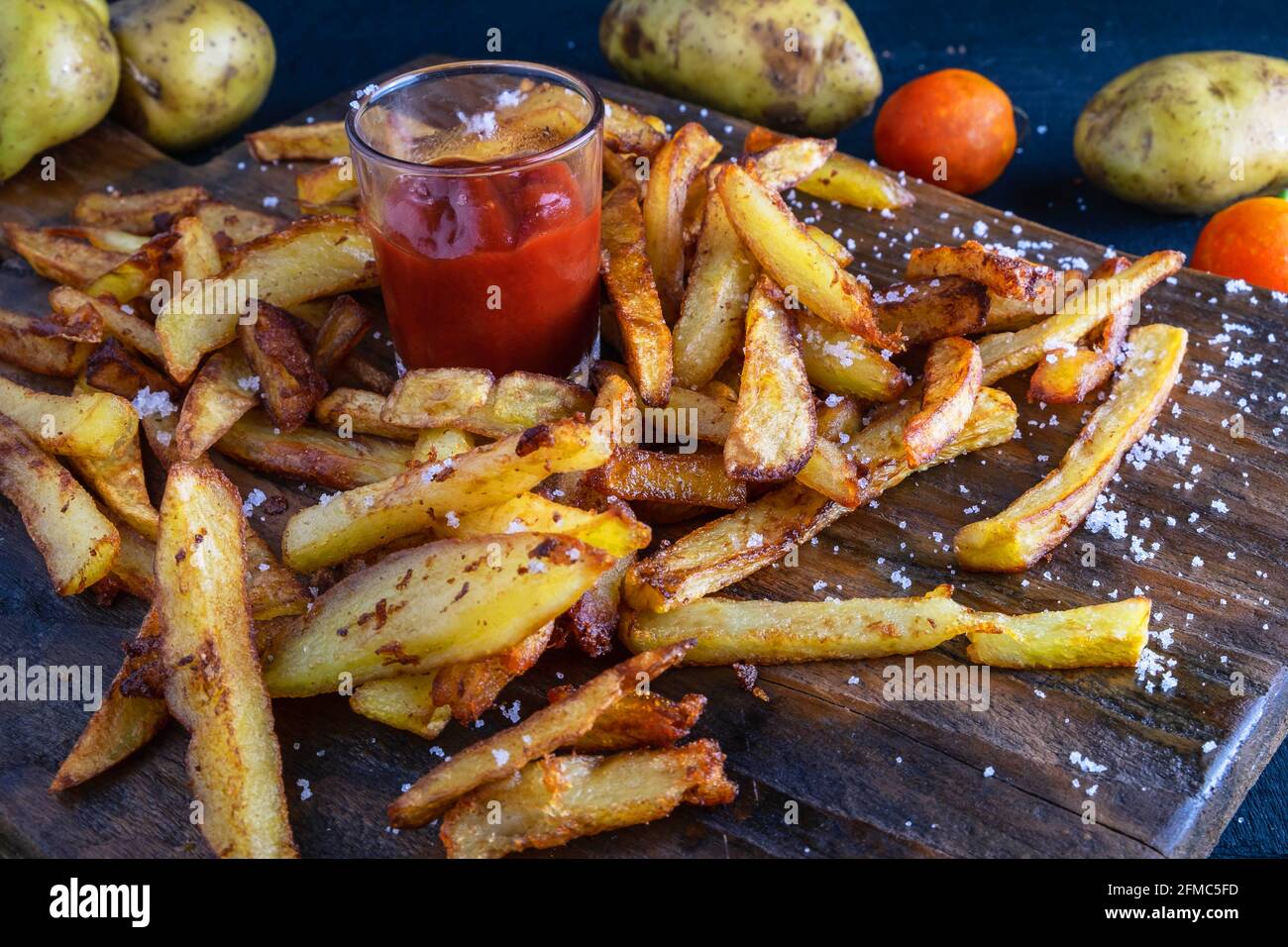 Frites de pommes de terre maison avec ketchup sur fond en bois Banque D'Images