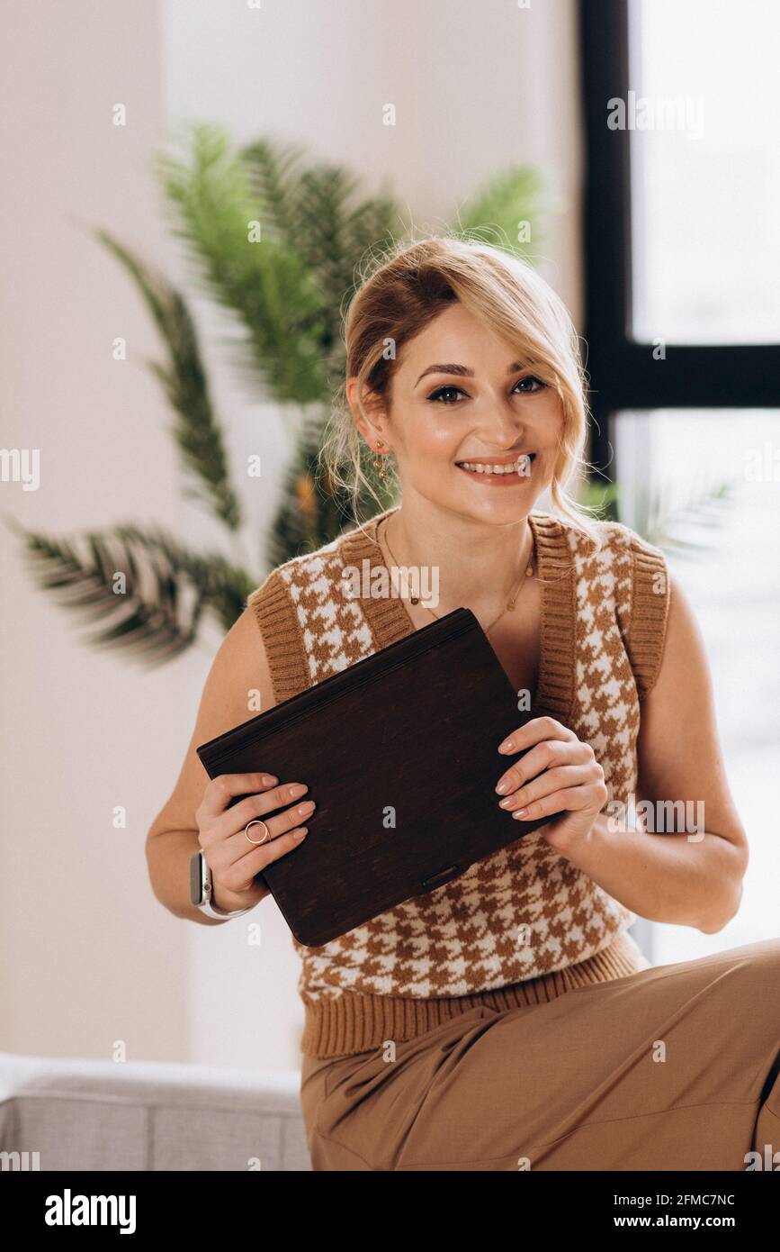 Belle femme blonde avec une boîte cadeau dans ses mains. Cadeau d'anniversaire, fête des femmes, fête des mères. Mise au point sélective douce, flou artistique, bruit de flou artistique. Banque D'Images