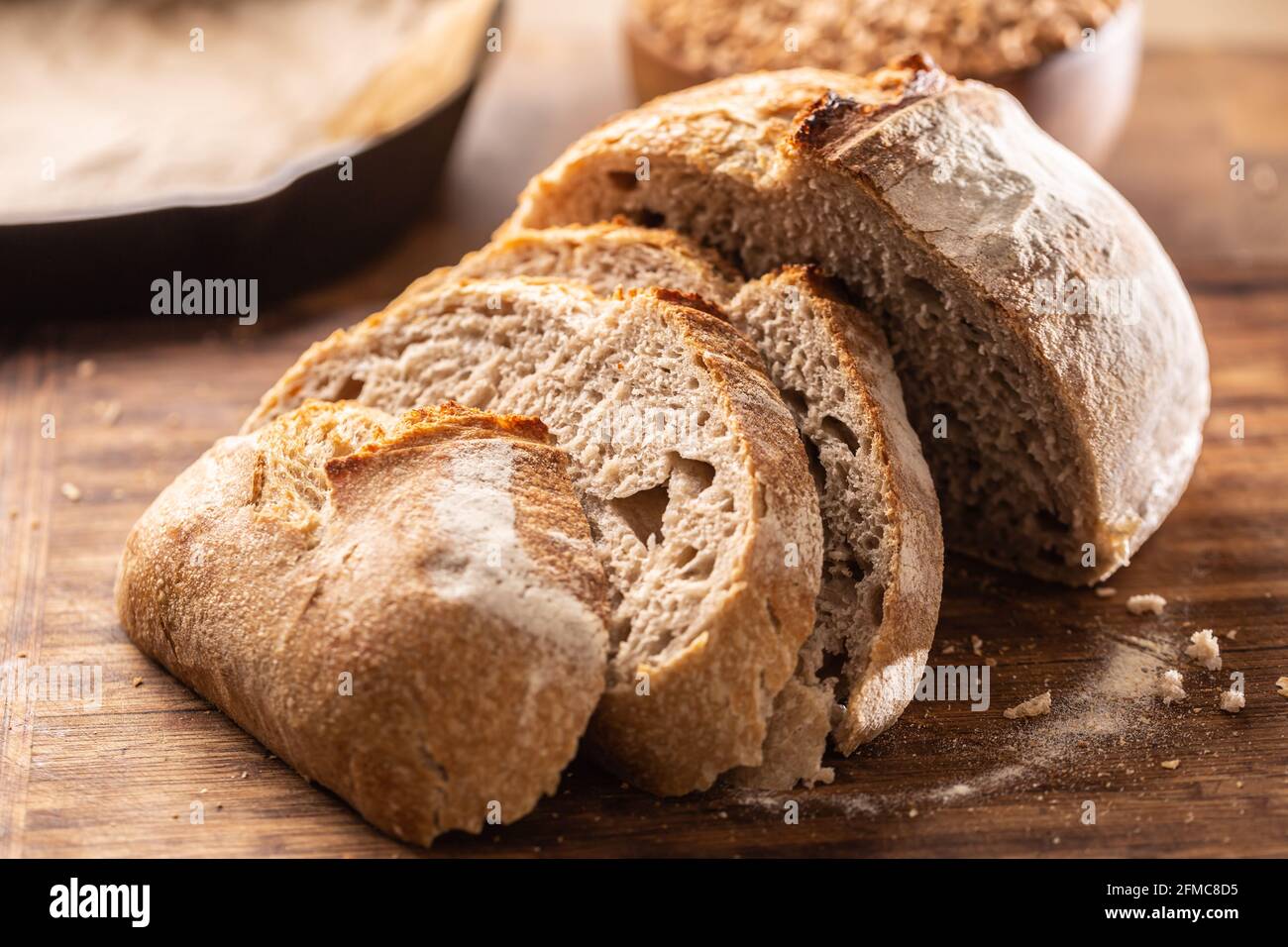 Tranches de pain de levure salées et croquantes avec grains de blé entier en arrière-plan. Banque D'Images