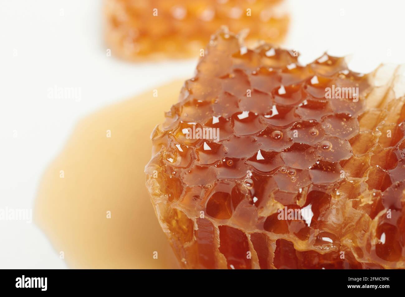 Miel orange en peigne macro vue rapprochée dans l'assiette Banque D'Images