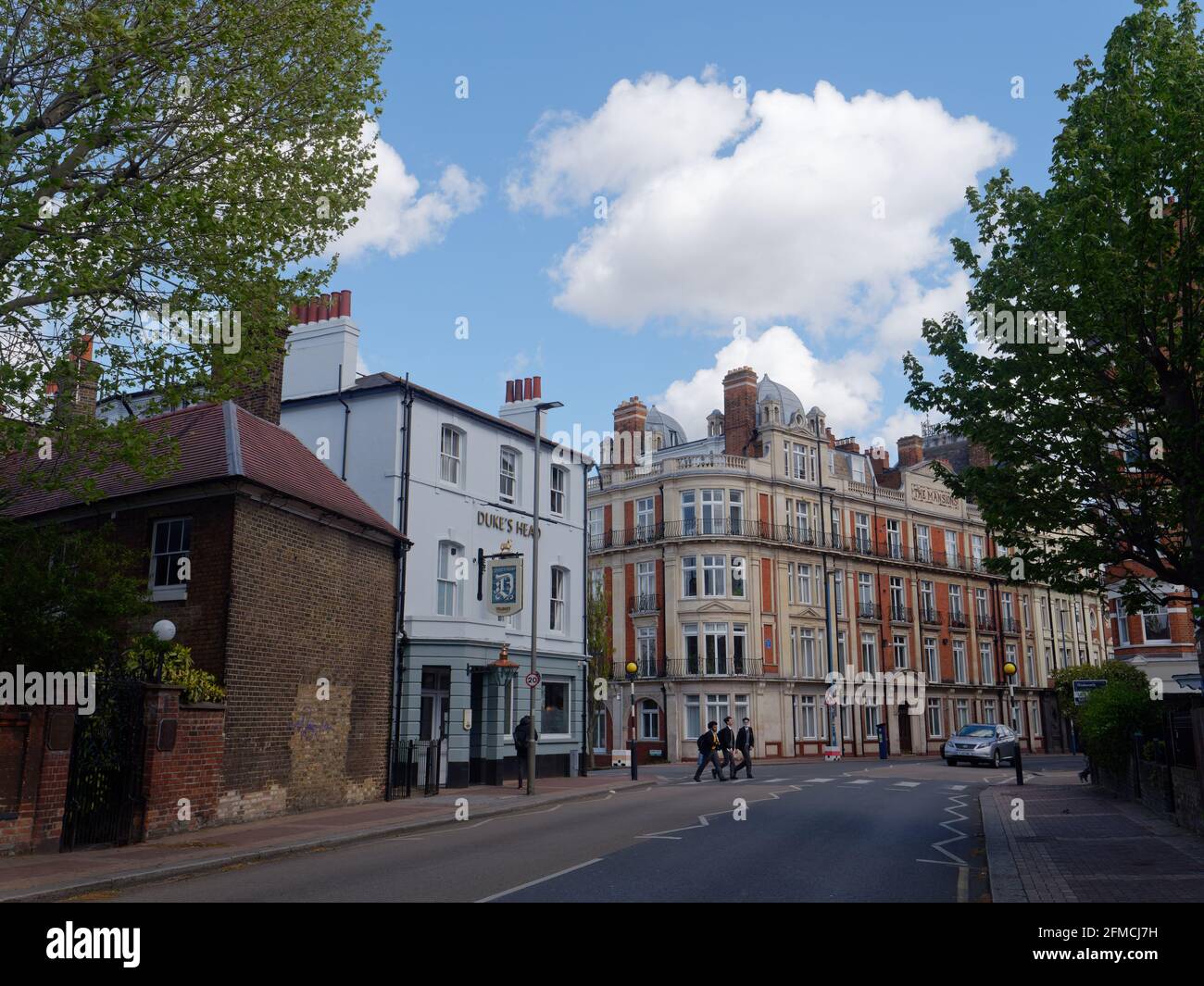 Putney, Grand Londres, Angleterre - mai 04 2021 : les écoliers traversent la route sur Lower Richmond Rd avec le pub de Duke's Head à gauche. Banque D'Images