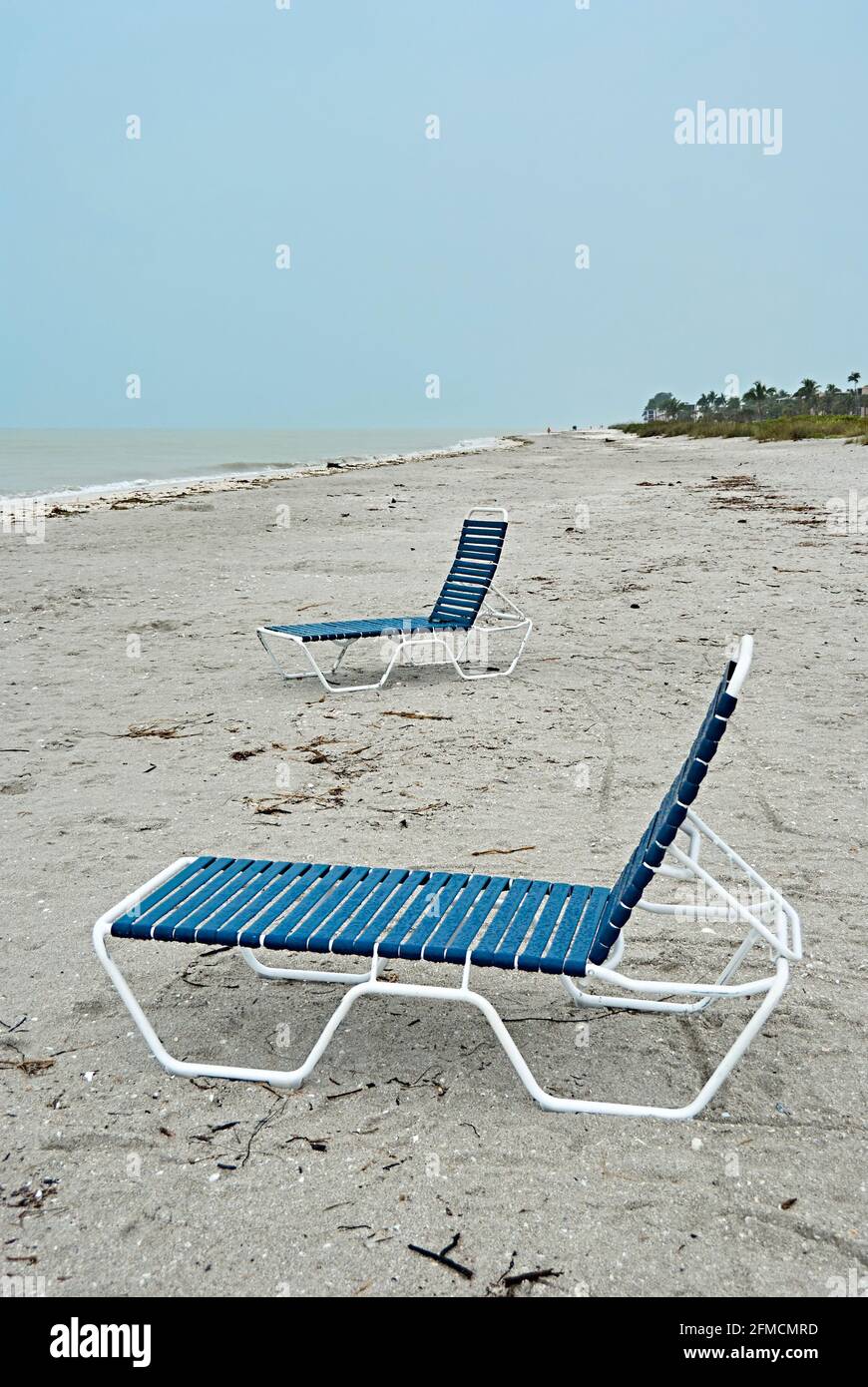 Deux chaises longues vides sur une plage vide sans touristes Banque D'Images
