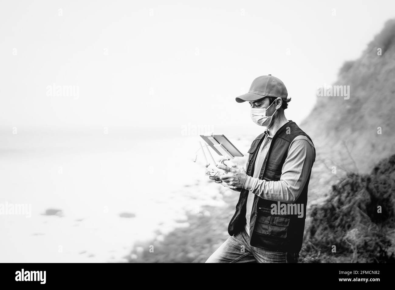 Un ingénieur de sexe masculin effectue une inspection à l'aide d'un drone tout en portant un masque facial Pour éviter la propagation du virus corona - technologie et concept industriel Banque D'Images