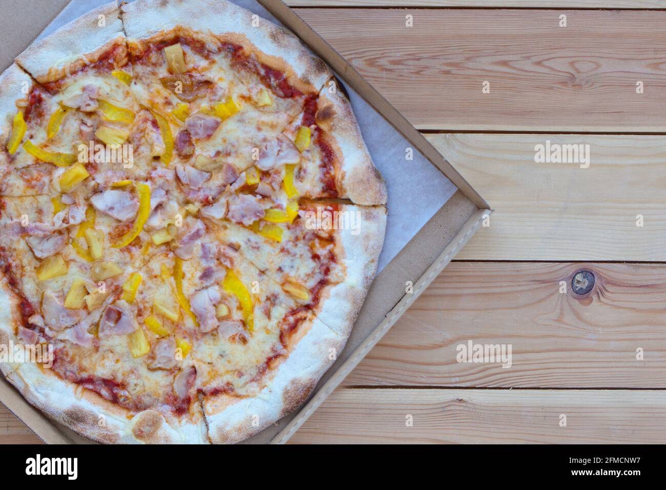 Pizza dans une boîte en carton sur fond en bois. Espace pour le texte. Vue de dessus. Livraison de pizza. Menu pizza. Pizza italienne. Pizza Tonda Romana Banque D'Images